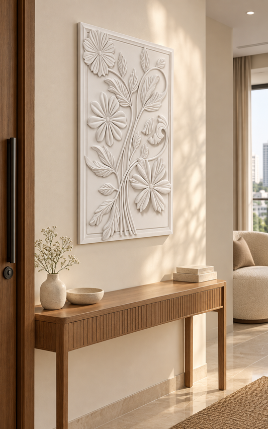 Three Blossom Leaf Scroll Corian wall panel, left view in a Mumbai entrance lounge with a cream wall, narrow oak console and boucle chair.