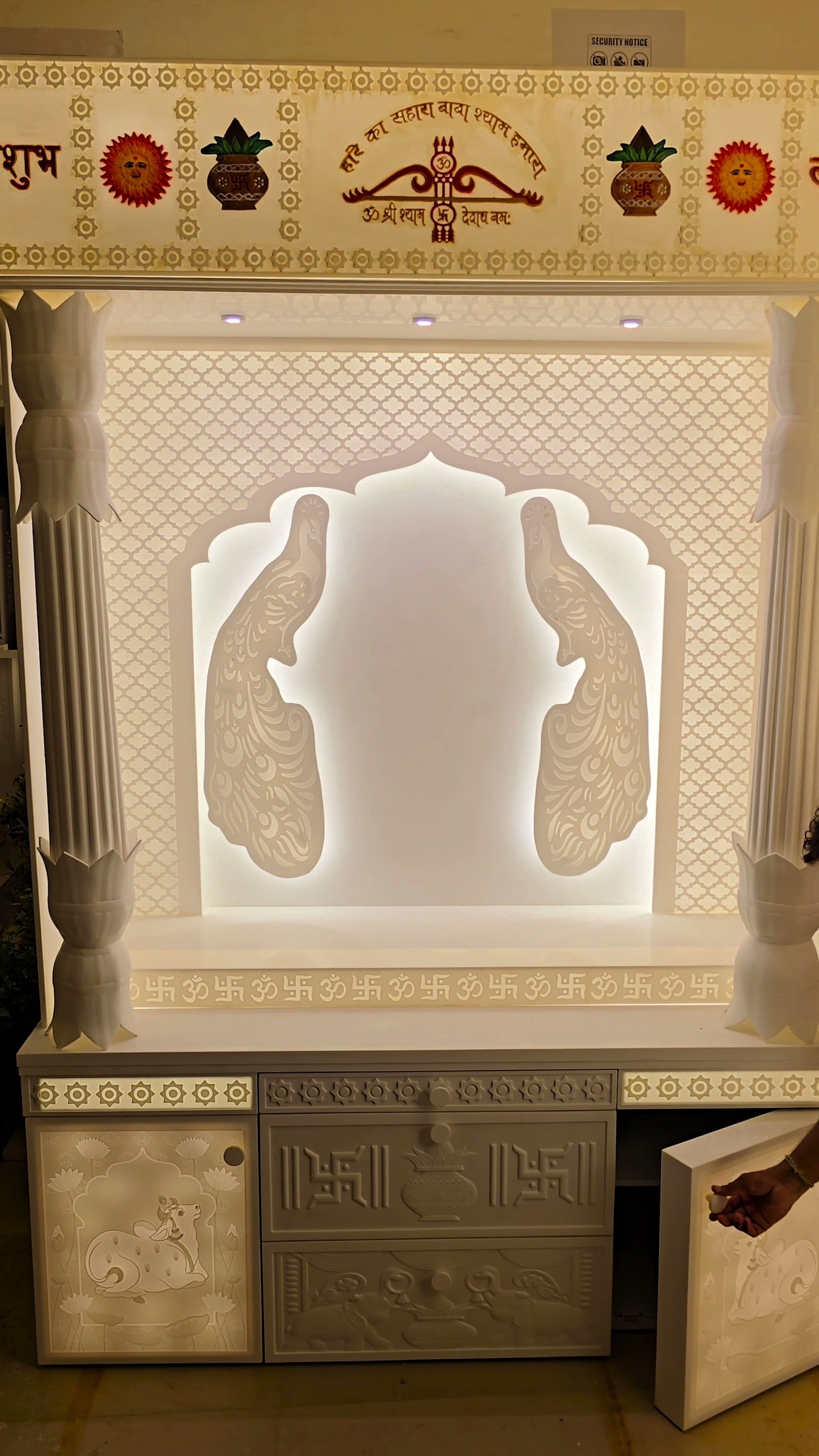 Continuous OM Swastik fretwork border at base plinth