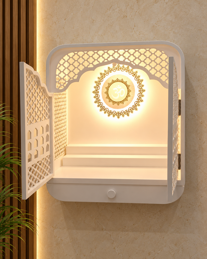 Open-door front view of the compact Corian mandir, showing the backlit Om, gold-coloured detailing and utility step; digitally styled background.