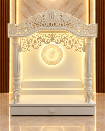 Front view of the traditional Corian mandir with ornate arch, round fluted pillars, elephant bases and backlit feather medallion. Reference-guided styled visualization.