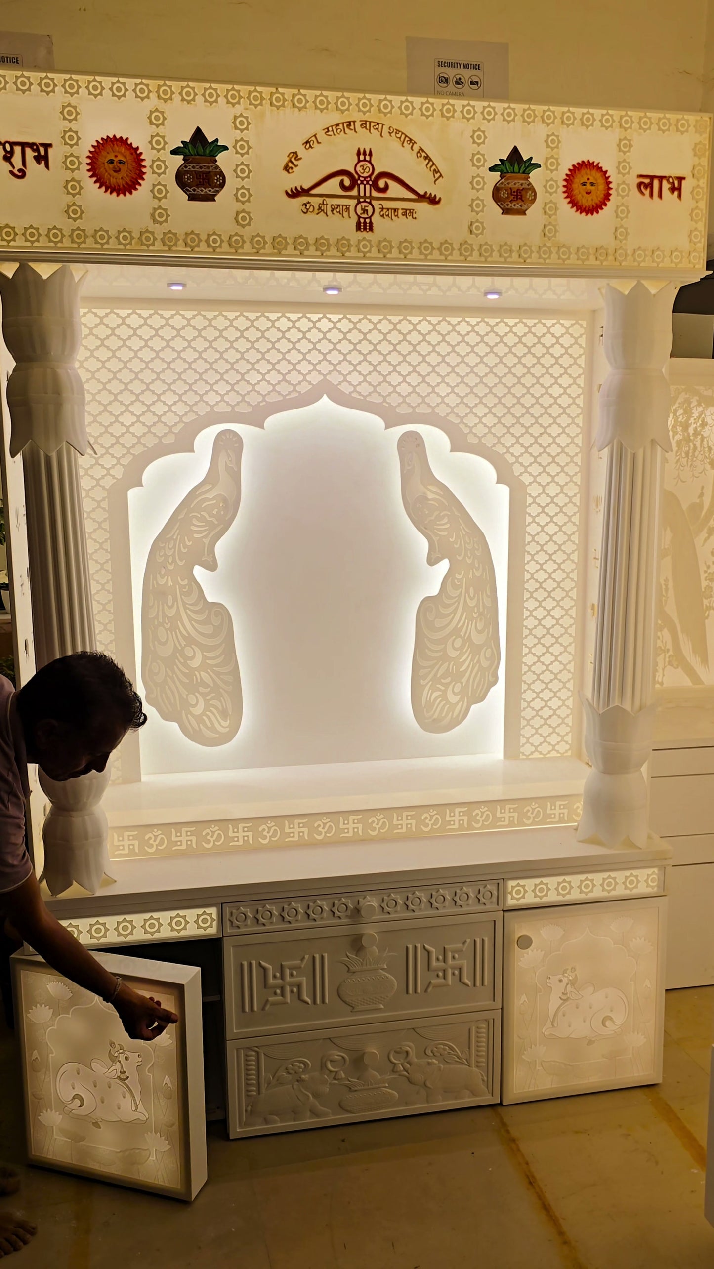 Scale reference walking past 8ft Corian mandir with traditional pillars