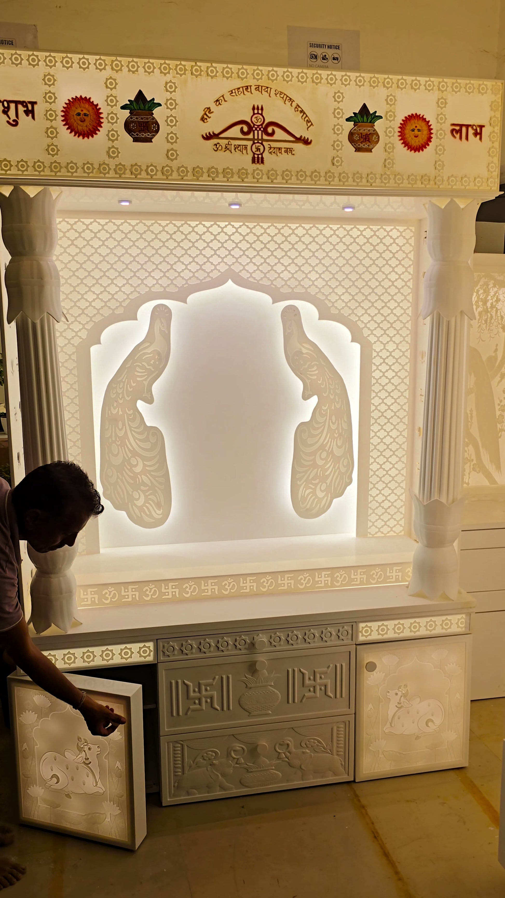 Scale reference walking past 8ft Corian mandir with traditional pillars